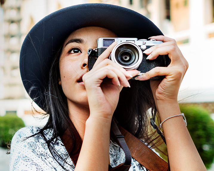 Southern Cross Travel Insurance - member offer A woman on holiday in Asia, taking a photo of her surroundings